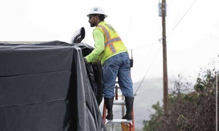 Photo: Worker covers a load for removal
