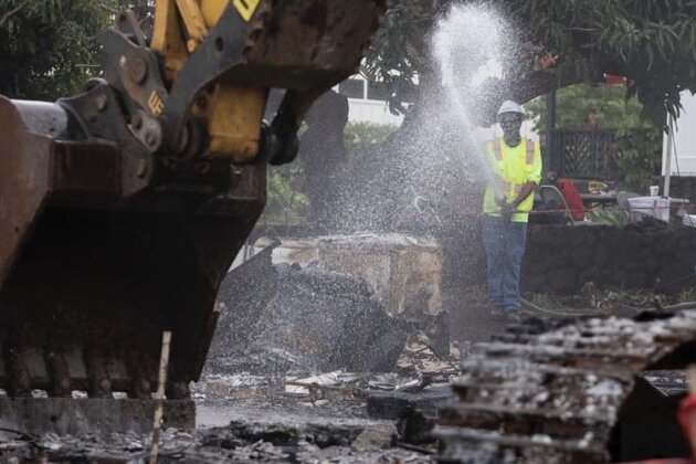 Photo: Workers use hoses to mitigate dust from the cleanup effort