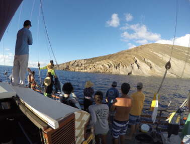 Photo: The crew of Hikianalia gaze toward the island of Lehua