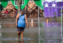 OHA Activates Nearly $4 Million in Disaster Aid Photo: Kane wading Wading through flood waters at Hui Mahiʻai ʻĀina