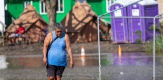 OHA Activates Nearly $4 Million in Disaster Aid Photo: Kane wading Wading through flood waters at Hui Mahiʻai ʻĀina