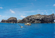 20 Years of Pono Management in Papahānaumokuākea Photo: The voyaging canoe, Makaliʻi, approaches Mokumanamana